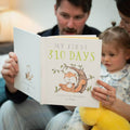 Father reading personalised Father's Day book 'My First 310 Days – A Story for My Daddy by Blake' with his partner and young child – heartfelt keepsake gift for a new dad’s first Father's Day.