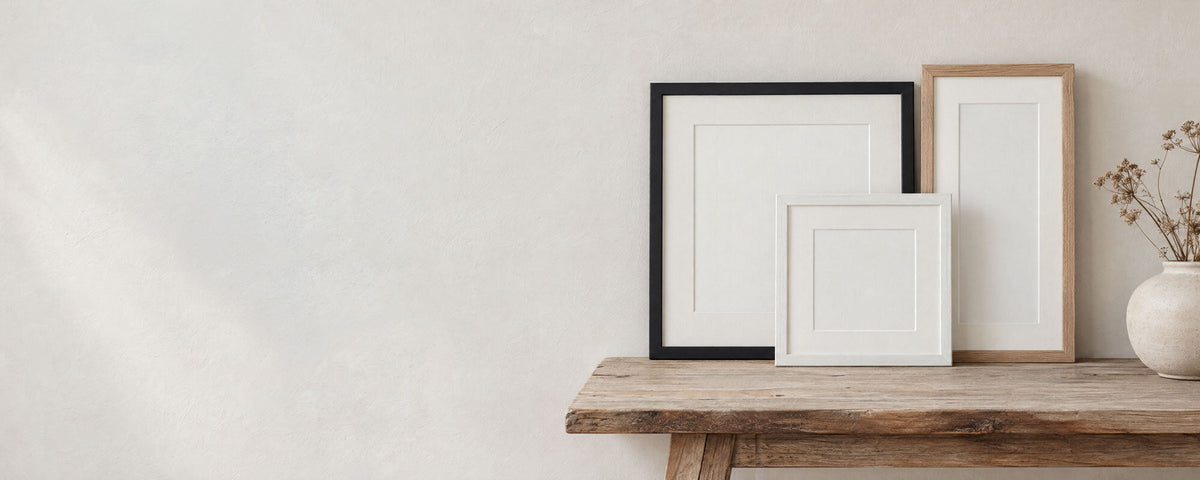 Black, white and oak frames with white mounts on a wooden bench